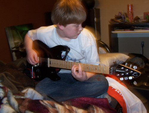 Michael plays his electric guitar...